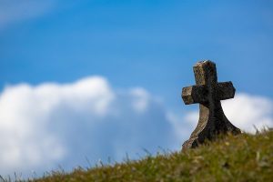 A cross on grass outside.