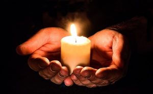 A candle in open hands.